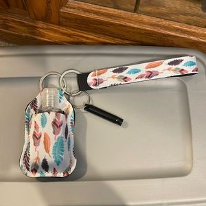 Hand sanitizer holder with safety whistle